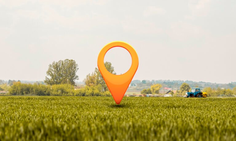 Orange location pin standing in a green landscape, representing Ambejogai Road as an area to explore for Best Location Flats in Latur.