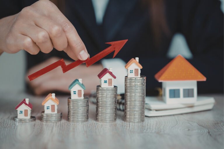 Miniature houses on rising stacks of coins with an upward growth arrow illustrating the investment potential of Best Location Flats in Latur.